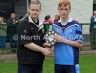 North Antrim GAA Chairmain Owen Elliott presentring St MacNissi captain Ciaran McGill with the North Antrim U14B 